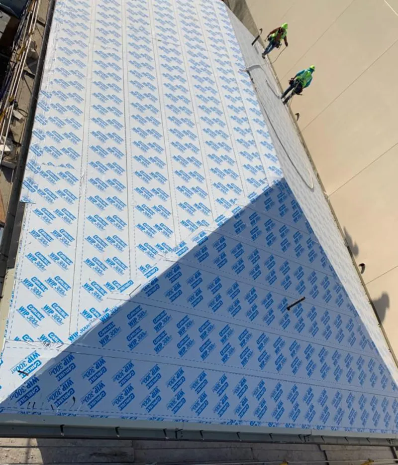 Professional roofers installing underlayment on a metal roof in Salamanca